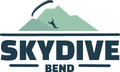 Logo showing a silhouetted skydiver descending over stylized mountains with the text "Skydive Bend" below.